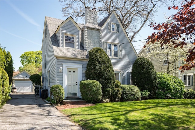 173 Pine St, Rockville Centre, NY 11570 - view of front of house featuring a chimney, an outdoor structure, a front yard, a garage, and central air condition unit