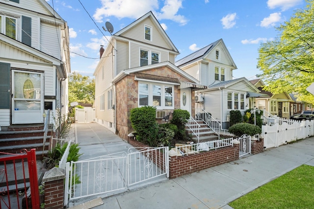 view of front of house featuring a gate, entry steps, and a fenced front yard