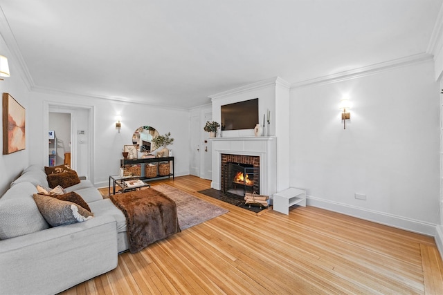 living room with a fireplace, ornamental molding, wood finished floors, and baseboards