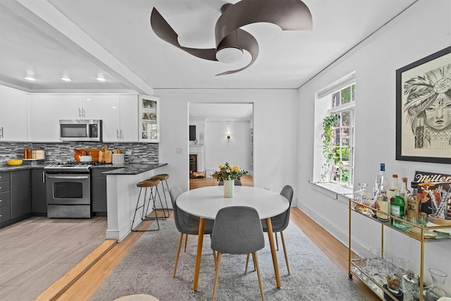 dining space with light wood finished floors and recessed lighting