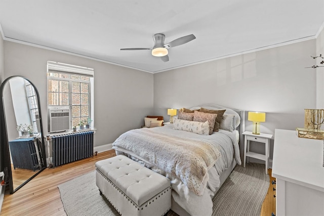 bedroom with radiator heating unit, ornamental molding, light wood-style flooring, ceiling fan, and cooling unit