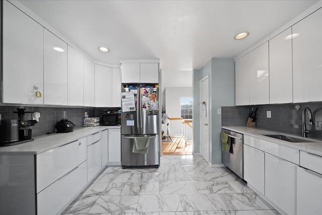 kitchen featuring a sink, recessed lighting, marble finish floor, and appliances with stainless steel finishes