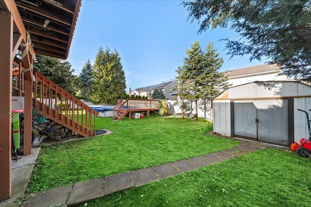 view of yard with a storage shed, an outbuilding, stairway, and a wooden deck