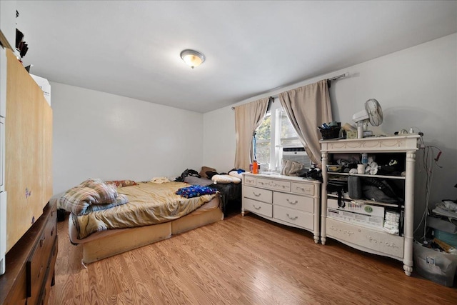 bedroom with cooling unit and wood finished floors