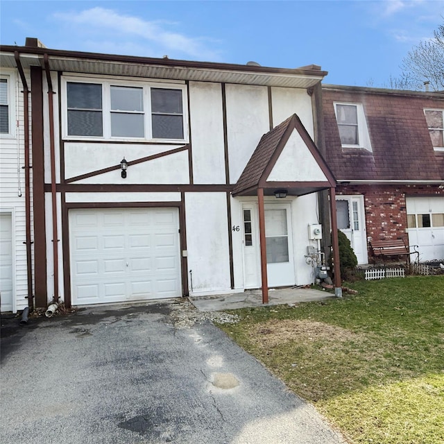 multi unit property with a front lawn, stucco siding, a garage, and aphalt driveway