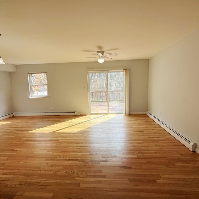 spare room with a ceiling fan, baseboards, baseboard heating, and wood finished floors