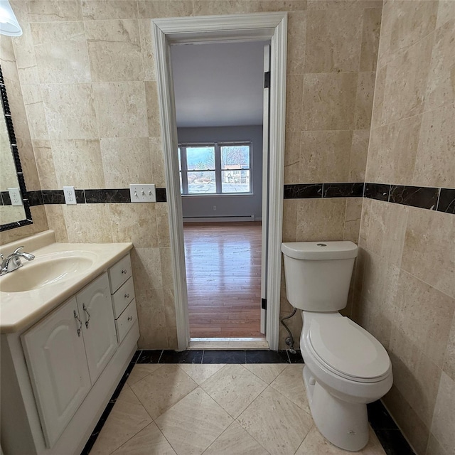 bathroom featuring toilet, tile walls, tile patterned flooring, vanity, and a baseboard radiator