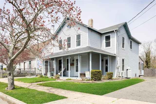 416 W St, Greenport, NY 11944 - view of front of property featuring a porch, fence, a chimney, and a front yard