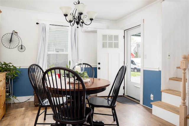416 W St, Greenport, NY 11944 - dining area featuring a wall mounted air conditioner, stairs, ornamental molding, light wood finished floors, and a chandelier