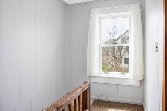 416 W St, Greenport, NY 11944 - interior space featuring baseboards, a wealth of natural light, wood walls, and carpet