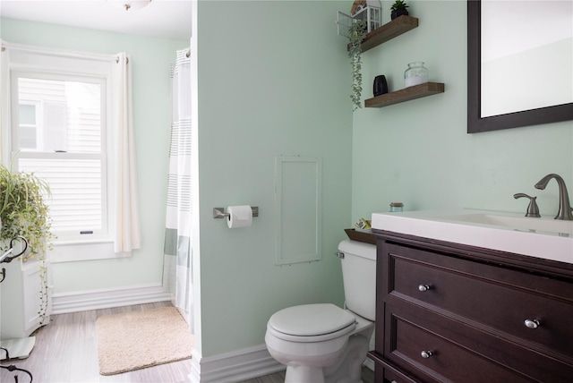 416 W St, Greenport, NY 11944 - bathroom with toilet, baseboards, vanity, and wood finished floors