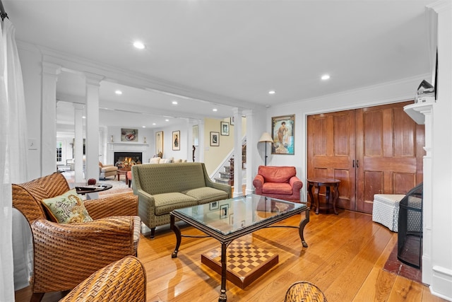 1005 Chapman St, Yorktown Heights, NY 10598 - living room featuring decorative columns, a warm lit fireplace, light wood-type flooring, crown molding, and recessed lighting