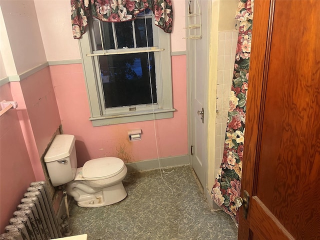 full bathroom featuring curtained shower, toilet, and radiator