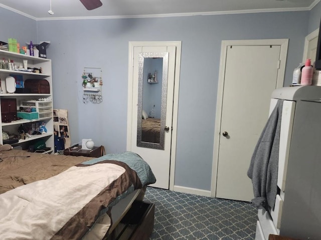 bedroom featuring crown molding, baseboards, and dark carpet