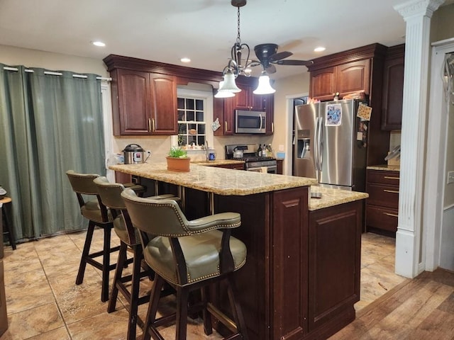 kitchen featuring recessed lighting, pendant lighting, a kitchen breakfast bar, and appliances with stainless steel finishes