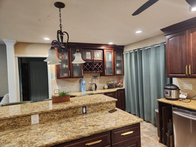 kitchen featuring hanging light fixtures, dishwasher, decorative backsplash, and glass insert cabinets