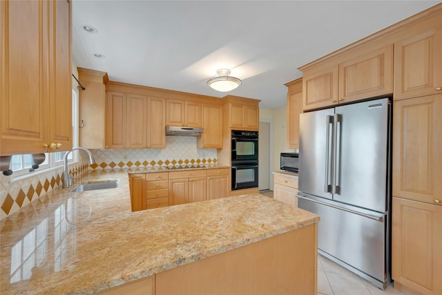 kitchen with light brown cabinetry, light stone countertops, a sink, black appliances, and tasteful backsplash