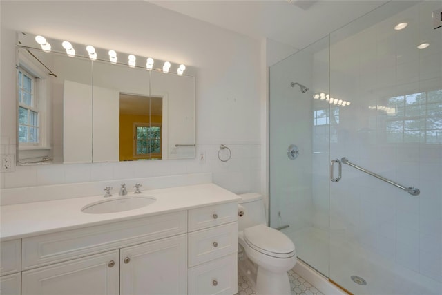 full bathroom with vanity, toilet, tile walls, and a shower stall