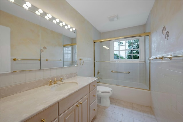 full bath with tile walls, vanity, visible vents, tile patterned floors, and combined bath / shower with glass door