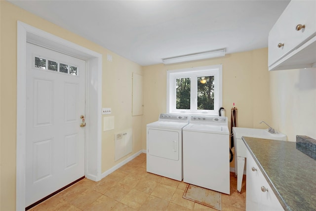 washroom featuring cabinet space, washing machine and dryer, and baseboards