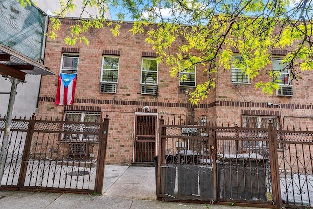 exterior space featuring a fenced front yard, brick siding, and a gate