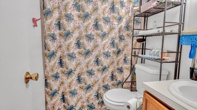 bathroom featuring toilet, vanity, and a shower with curtain