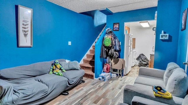 living room with stairway, a textured ceiling, and wood finished floors