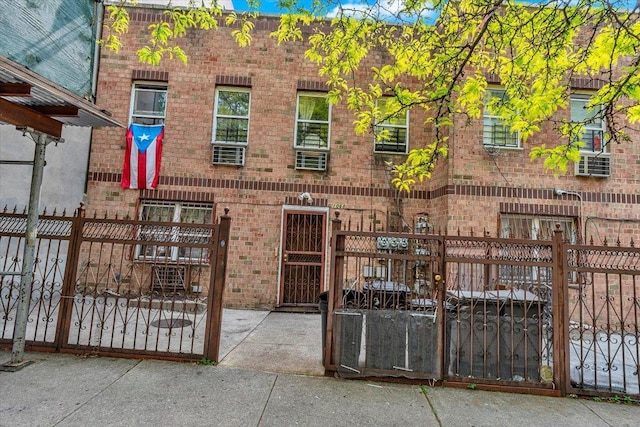 exterior space with a fenced front yard, brick siding, and a gate