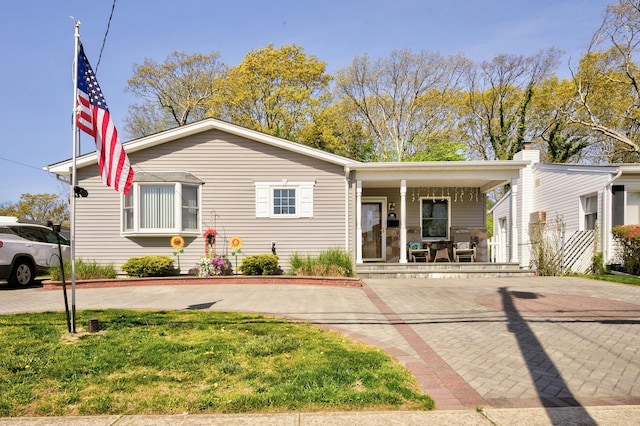 view of front of house featuring covered porch and a front lawn