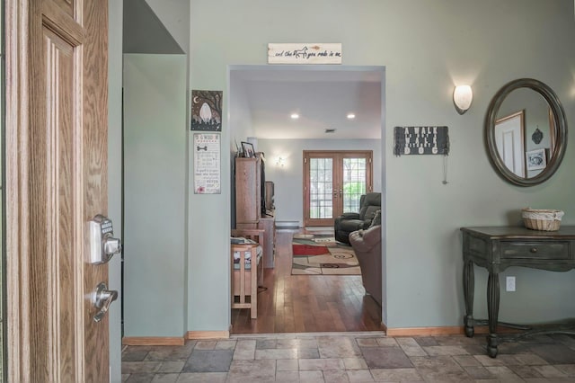foyer featuring baseboards, french doors, and stone tile flooring