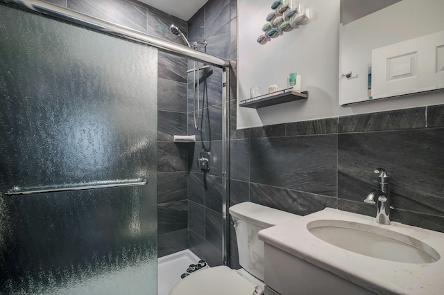 full bathroom with tile walls, toilet, a shower stall, and vanity