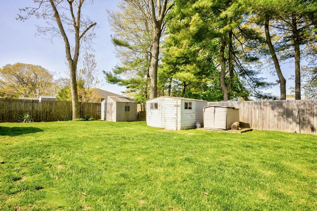 view of yard featuring a storage shed, an outbuilding, and a fenced backyard