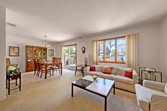 living room with a chandelier, light colored carpet, and visible vents