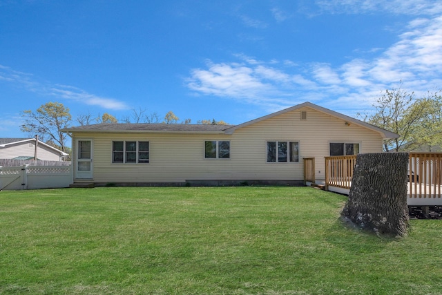 back of property featuring a yard, fence, and a wooden deck
