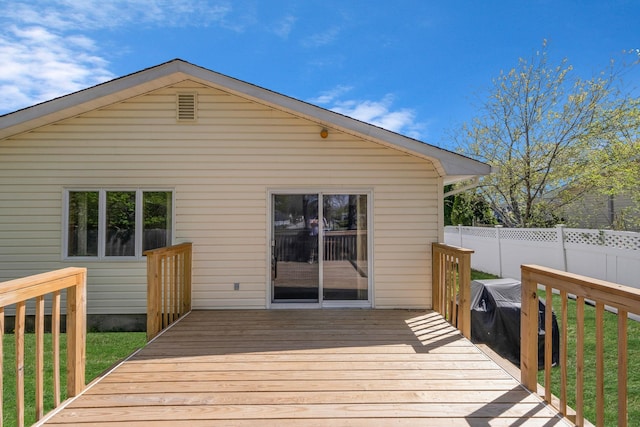 wooden terrace featuring fence and a lawn