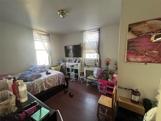 bedroom with cooling unit and wood finished floors