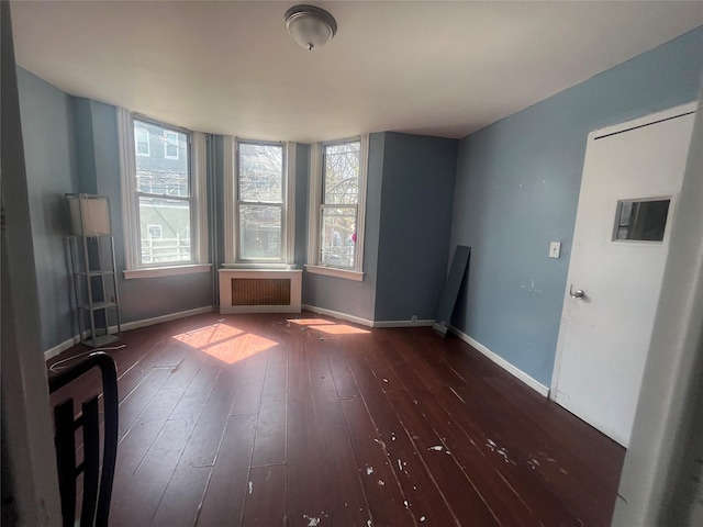 interior space with radiator heating unit, baseboards, and dark wood-style floors