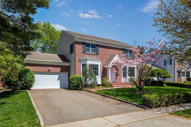 131 2nd St, Garden City, NY 11530 - colonial-style house featuring an attached garage, driveway, brick siding, a front lawn, and roof with shingles
