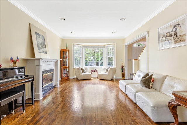 131 2nd St, Garden City, NY 11530 - living area with wood finished floors, crown molding, a glass covered fireplace, baseboards, and recessed lighting