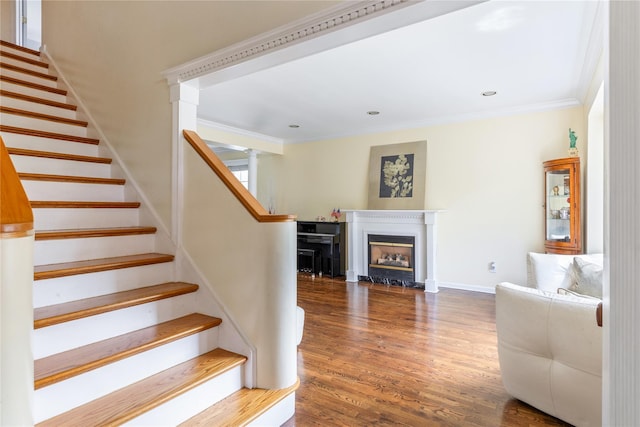 131 2nd St, Garden City, NY 11530 - staircase featuring crown molding, wood finished floors, a fireplace with flush hearth, baseboards, and recessed lighting