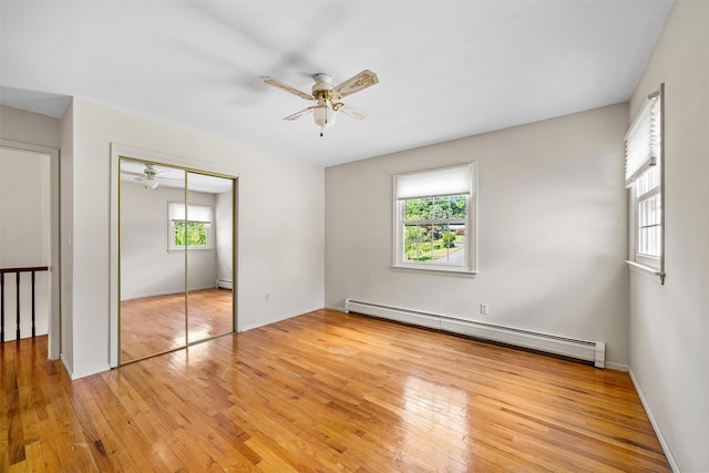 35 Capt Faldermeyer Dr, Stony Point, NY 10980 - unfurnished bedroom with a baseboard radiator, multiple windows, light wood-style flooring, and a closet