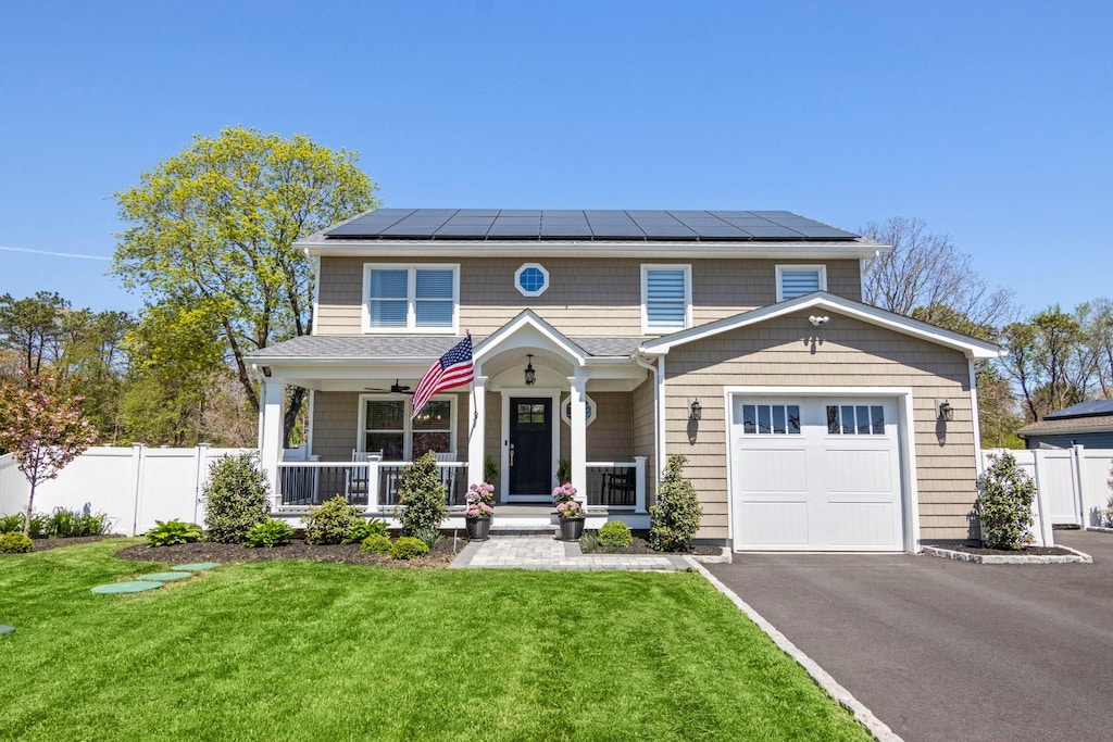 47 Amityville St, Islip Terrace, NY 11752 - view of front facade with covered porch, solar panels, asphalt driveway, and an attached garage