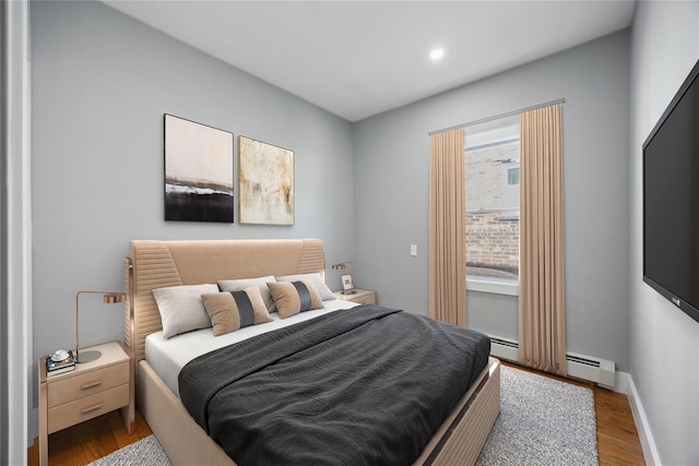 bedroom featuring recessed lighting, baseboards, baseboard heating, and wood finished floors