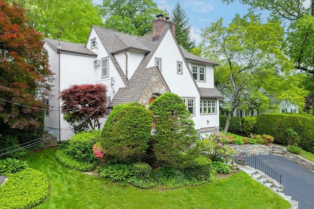 67 Walbrooke Rd, Scarsdale, NY 10583 - view of side of home featuring stucco siding, a chimney, roof with shingles, and a yard