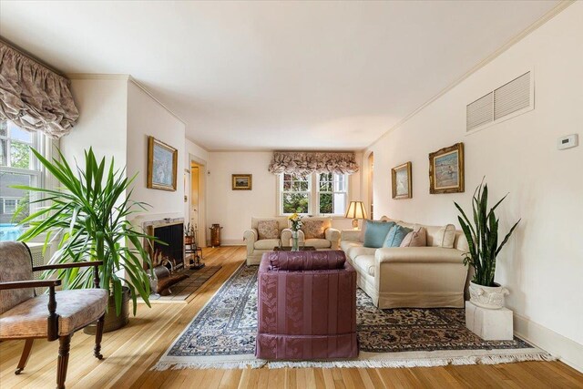 67 Walbrooke Rd, Scarsdale, NY 10583 - living area featuring hardwood / wood-style flooring, a lit fireplace, and crown molding