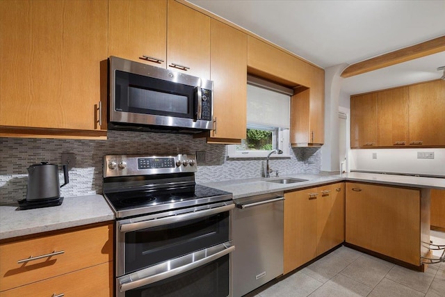 67 Walbrooke Rd, Scarsdale, NY 10583 - kitchen featuring stainless steel appliances, a sink, decorative backsplash, light tile patterned flooring, and light stone countertops
