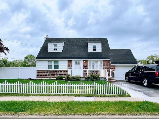 cape cod house featuring a front lawn, brick siding, and a garage