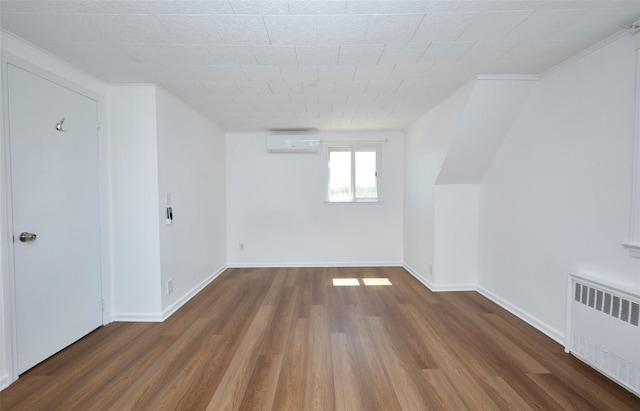 199 Guildford Ct, West Hempstead, NY 11552 - bonus room featuring radiator, a wall mounted air conditioner, wood finished floors, and baseboards