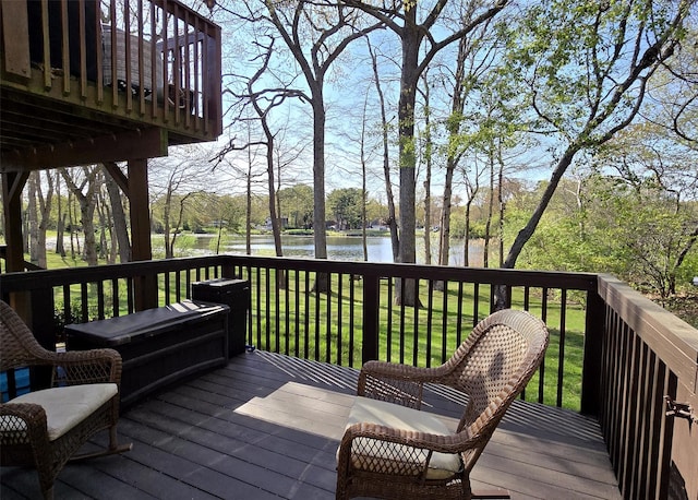 wooden deck with a yard and a water view