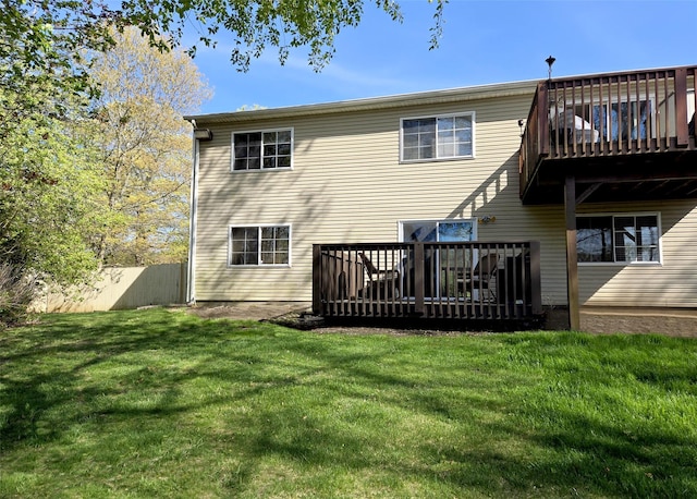 back of property featuring a yard, fence, and a wooden deck